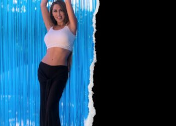 Una mujer sonriente, levantando los brazos en celebración, vestida con un top blanco y pantalones negros, con un fondo de luces de neón y texturas onduladas, promocionando la Fiesta 9 d’Octubre en Open-Minded.